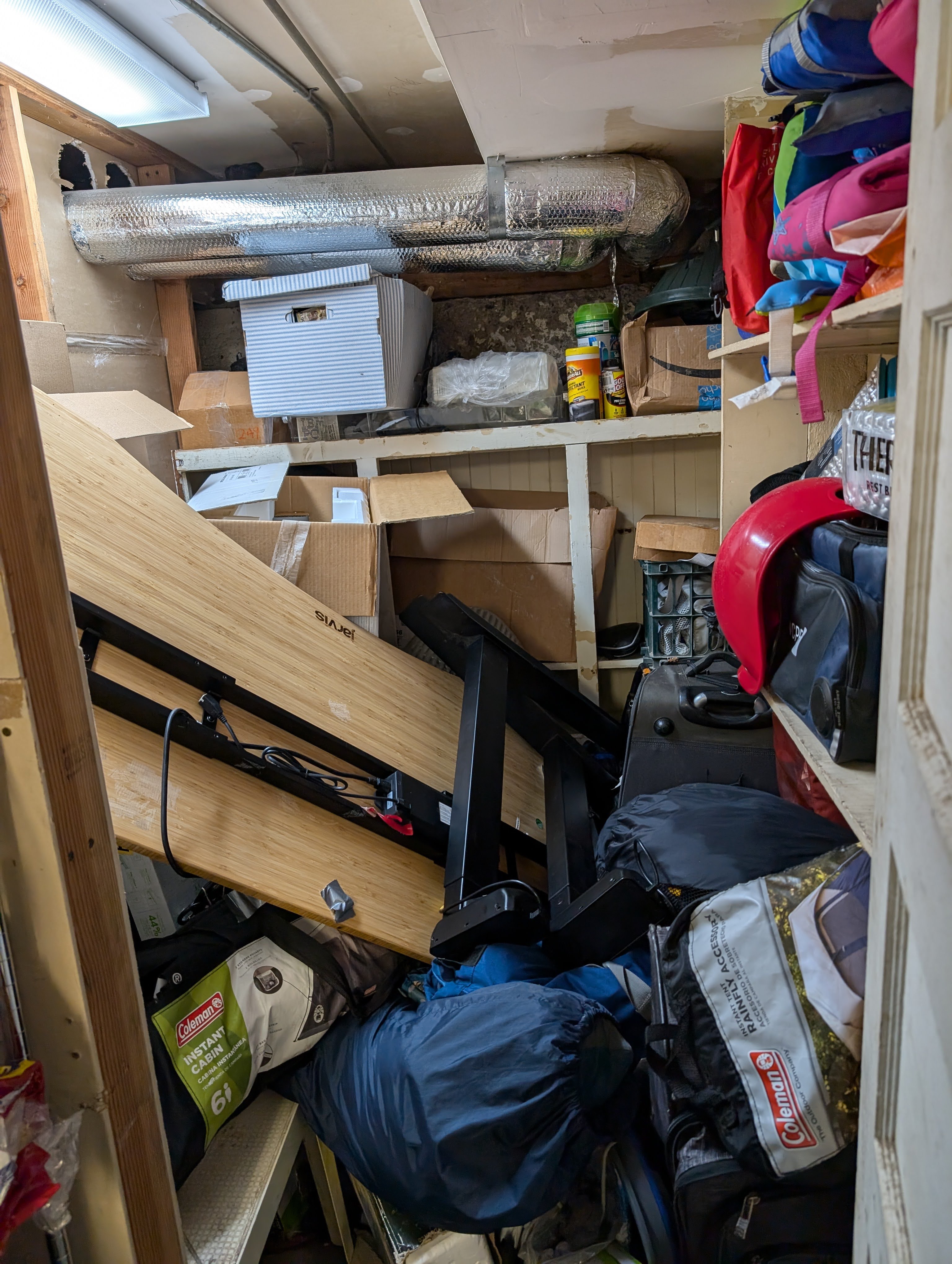 Cluttered storage closet before decluttering